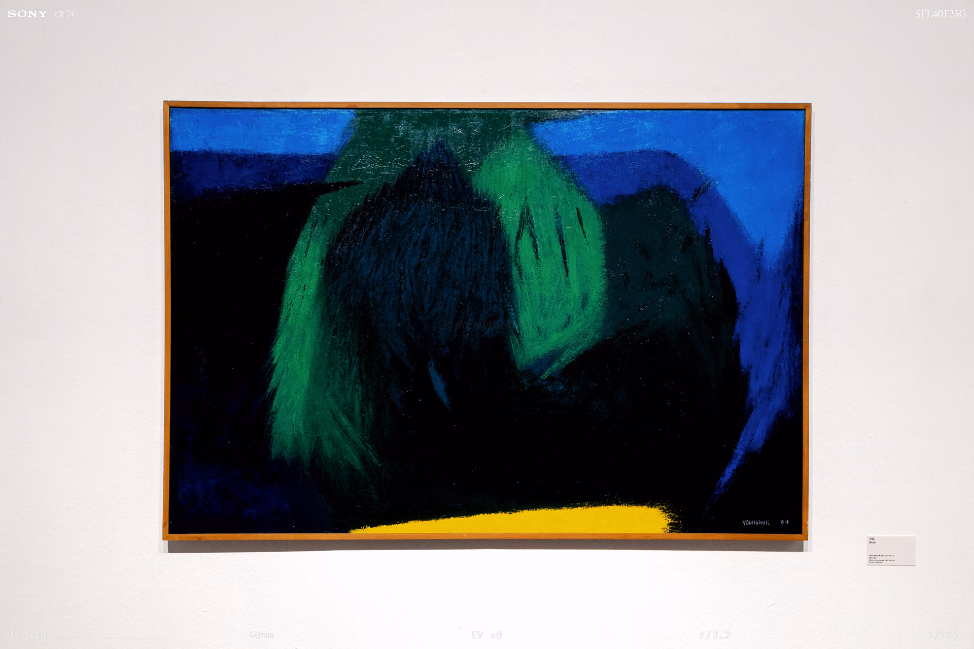 A painting divided into blue, green and black