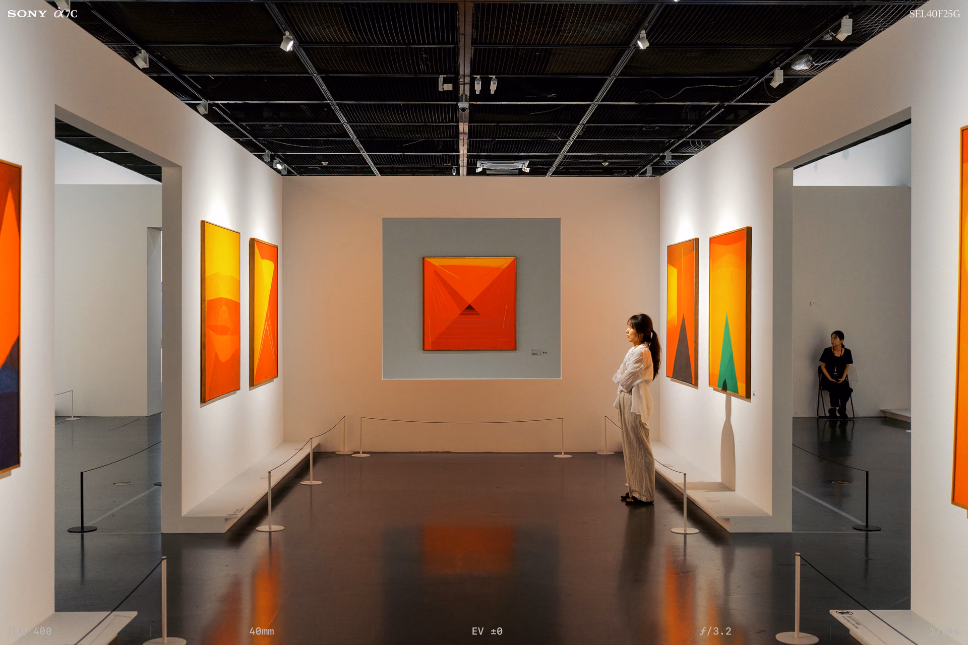 An orange square painting on a gray panel
