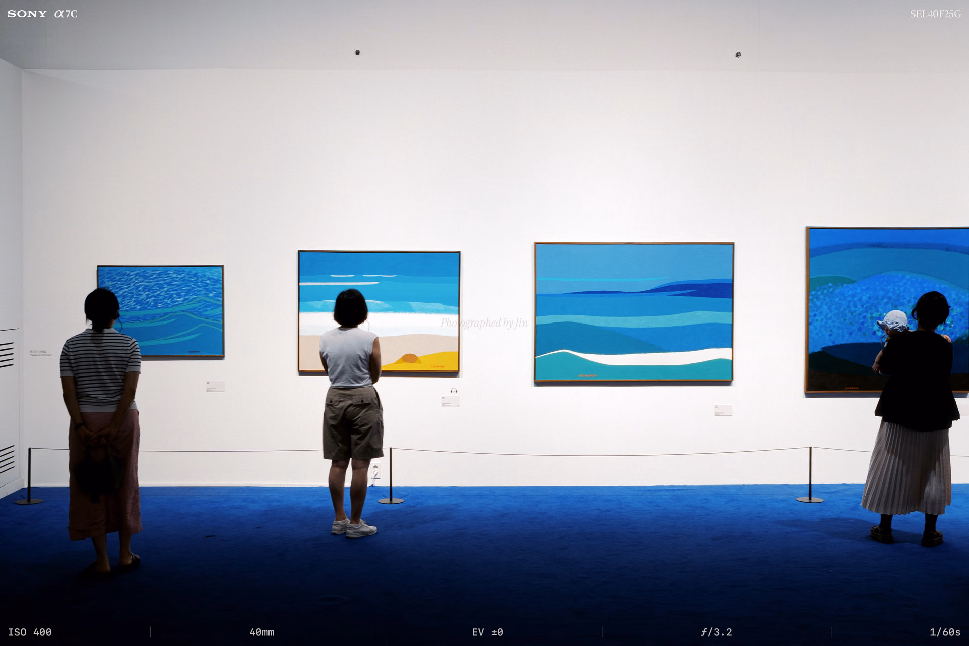 A blue room with sea paintings on every wall