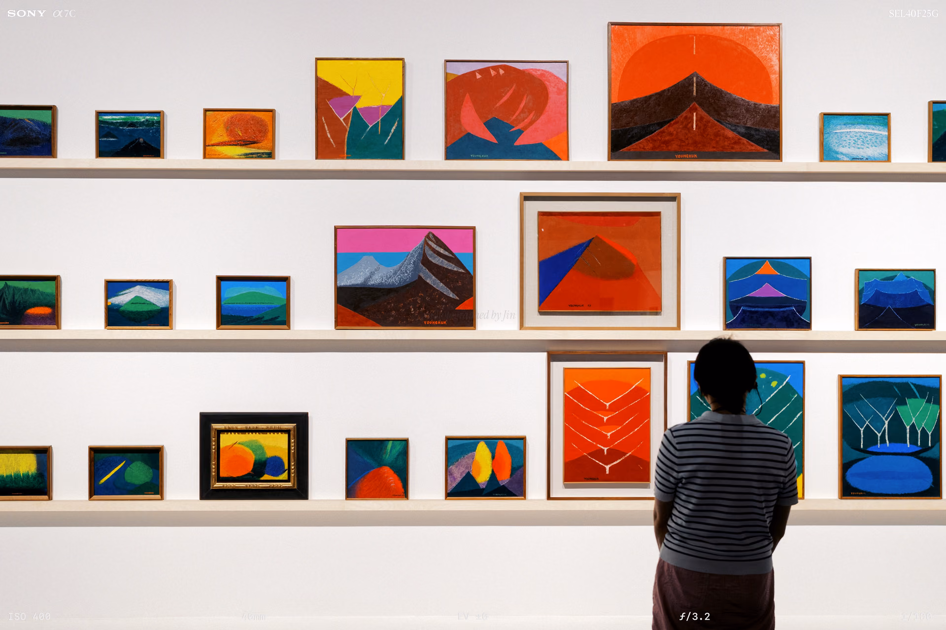 A wall filled with small paintings